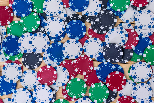 Closeup on colorful casino chips on wooden desk - Photo, Image