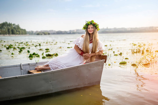 Menina bonita em vestido nacional em barco no lago
 - Foto, Imagem