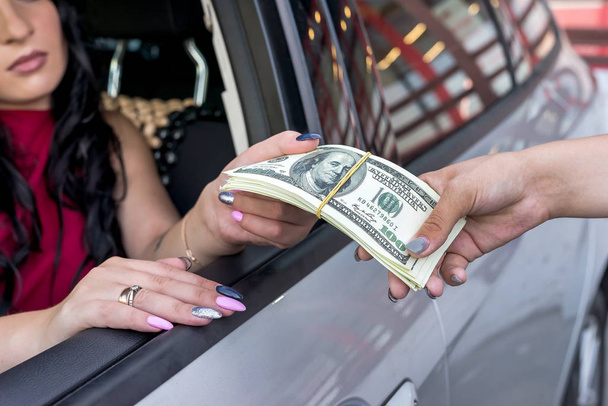 Kobiece ręce z dolarami i samochodem. - Zdjęcie, obraz