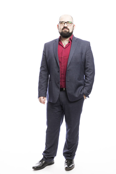 A bald man with glasses and a beard, dressed in a suit, stands with his eyes closed. Full height. Isolated on a white background.  - Foto, Imagem