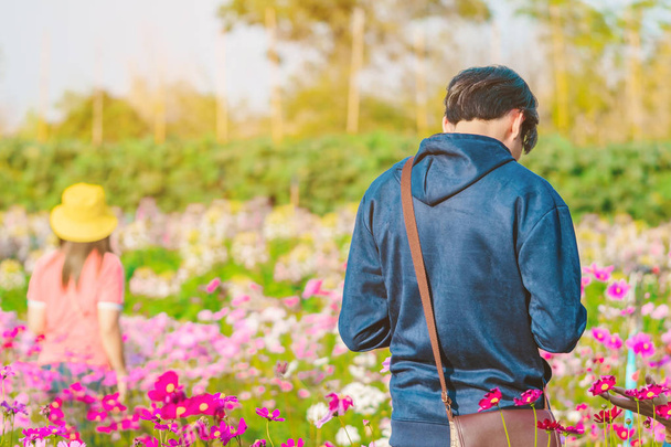 Felicidad Los turistas toman fotos con hermosas flores en flor por la tarde en Maple Garden. en Kanchanaburi, Tailandia. - Foto, Imagen