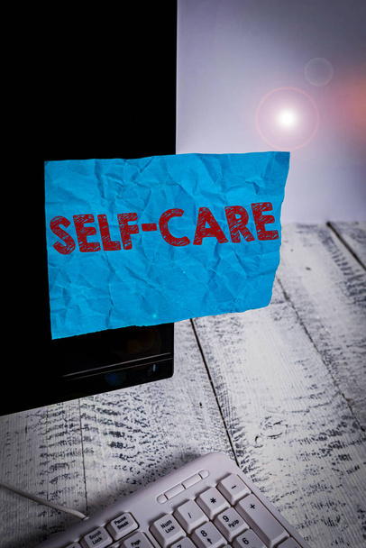 Käsiala teksti Self Care. Käsitteellinen kuva käytäntö ryhtyä toimiin yhden sekunnin parantamiseksi on oma terveys Merkintäpaperi teipattu mustan tietokoneen näytön lähelle valkoista näppäimistöä
 - Valokuva, kuva