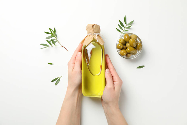 Female hands hold bottle with olive oil on white background, top - Foto, Imagem