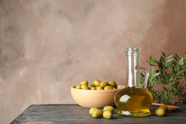 Composition with olive oil and olives on wooden table, close up - Photo, Image