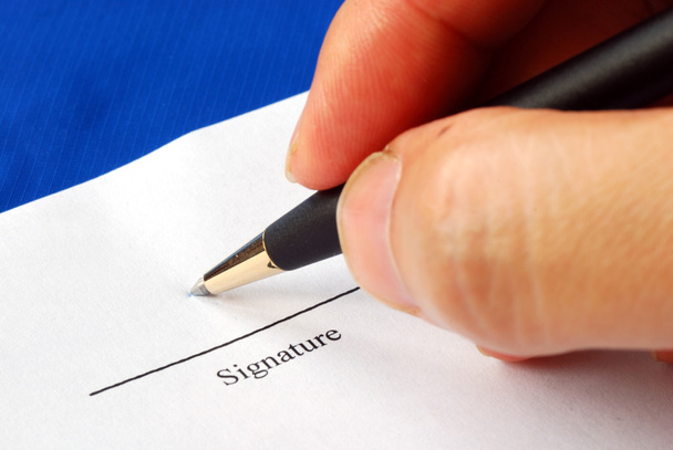 Sign the name on a paper with a pen isolated on blue - Photo, Image