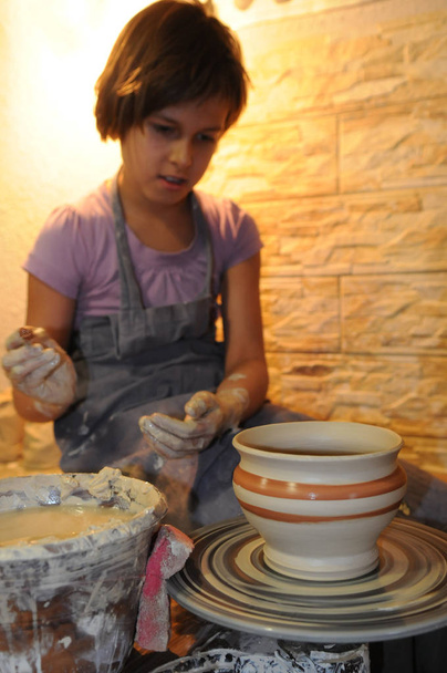 Chica admira su cerámica
 - Foto, Imagen