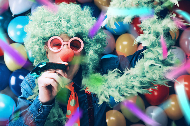 Crazy Young Party Man Having Fun at Carnival On Colorful Balloons Background - Φωτογραφία, εικόνα