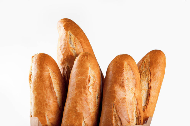 Baguette bread in paper bag on white background - Fotó, kép