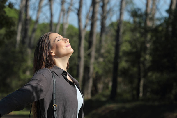 Satisfied woman breathing deeply fresh air enjoying sunshine - Foto, immagini
