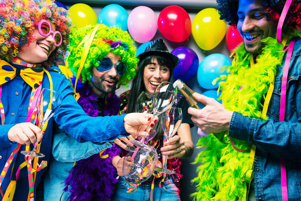 Felices jóvenes amigos bebiendo champán y celebrando durante la fiesta
 - Foto, Imagen