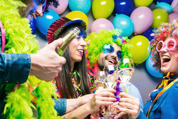 Gelukkig jonge mensen drinken champagne en vieren carnaval of Nieuwjaar  - Foto, afbeelding