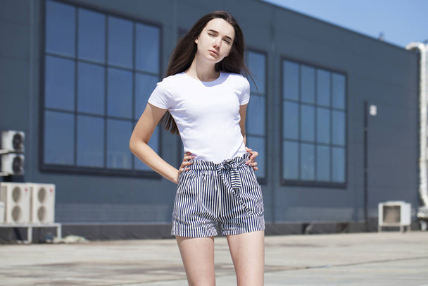 Pretty young brunette model in white summer blouse and jeans, su - Фото, зображення
