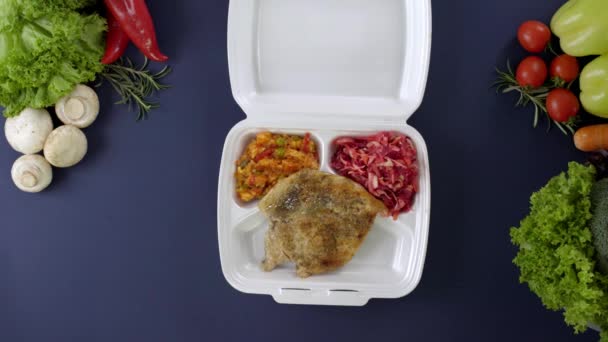 Balení jídla s sebou v polystyrénové krabici. Čerstvé jídlo s kuřecími prsíčky, rýží se zeleninou a salátem - Záběry, video