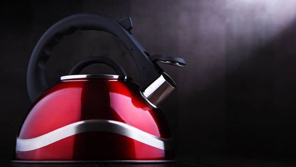 Червоний чайник з нержавіючої сталі з свистом
 - Фото, зображення