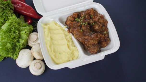 Συσκευασία takeaway τροφίμων σε κουτί από φελιζόλ. Φρέσκο γεύμα συσκευασίας παράδοσης με γκούλας και πουρέ πατάτας - Πλάνα, βίντεο