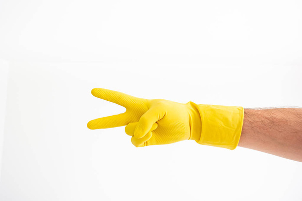 White Caucasian male hand with yellow latex glove showing showin - Photo, Image