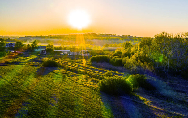 Kevät, auringonnousu kylän yllä, kaikki kylpeneet auringossa, aamu sumu, näkymä nelikopterista DJI
 - Valokuva, kuva
