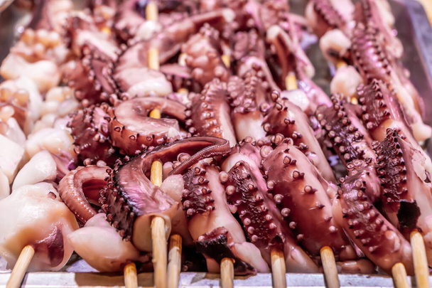 Pulpos exóticos de mariscos rosados en pinchos en Asia
 - Foto, Imagen