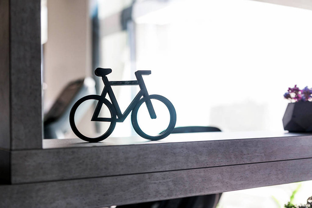 Ένα μικρό ποδήλατο ως διακοσμητικό στοιχείο στέκεται σε ένα ράφι - Φωτογραφία, εικόνα