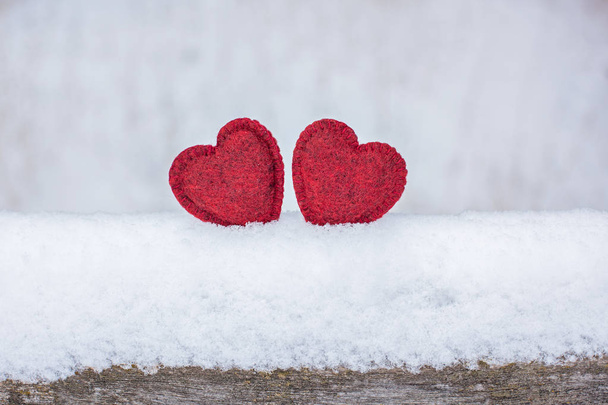 2 red textured woolen hearts in the snow, couple in love, declaration of love, background for Valentine's Day - Foto, Imagem