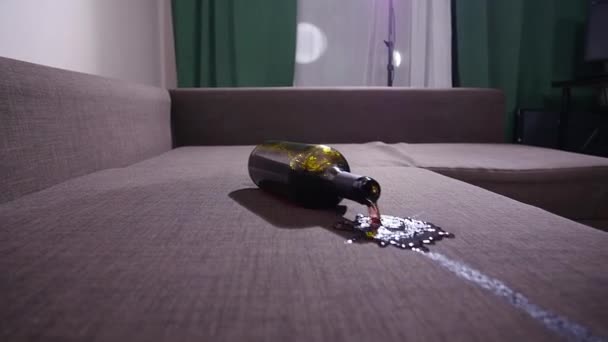 A bottle of wine falls on the sofa and spills wine. - Footage, Video