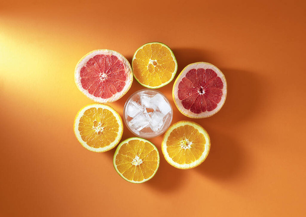 Snijd citrusvruchten en glas met ijs. Ingrediënten koude drank - Foto, afbeelding