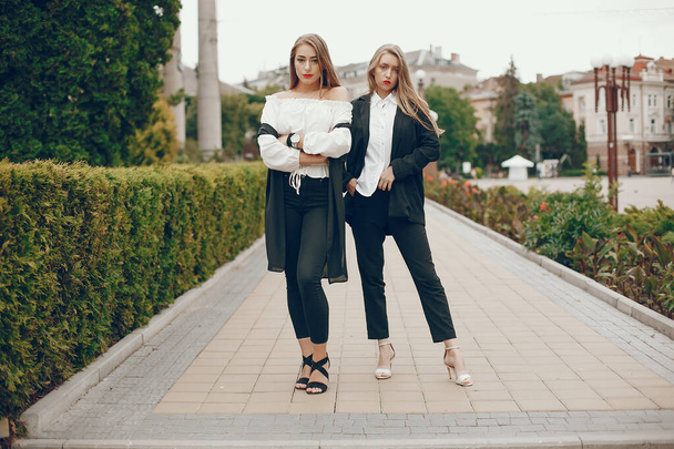 Two stylish girls in a summer city - Фото, изображение