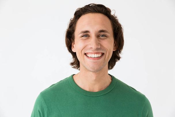 Image of handsome brunette man wearing basic t-shirt smiling at camera - Фото, изображение