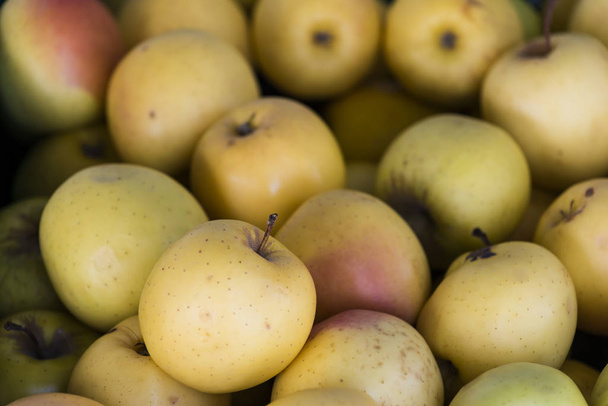 viele goldene Klassenäpfel in einem Obstladen gestapelt. - Foto, Bild