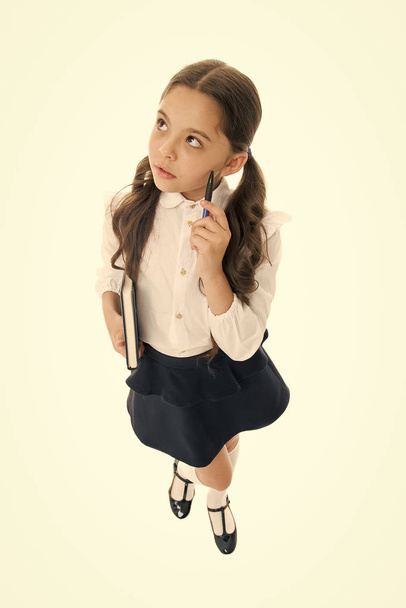 What if. Child school uniform kid doing homework. Girl school clothes hold book and pen. Girl cute write down idea notes. Notes to remember. Write essay or notes. Personal schedule. Making notes - Valokuva, kuva
