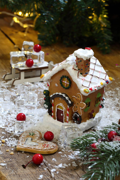 Gingerbread house in glaze on a wooden background - Φωτογραφία, εικόνα