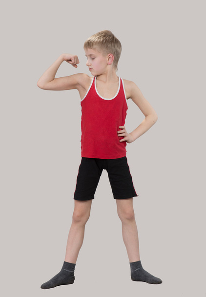 Boy looking at his muscles - 写真・画像