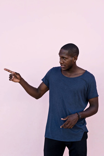 Πορτρέτο ενός Αφρικανού μπροστά από έναν πολύχρωμο τοίχο - Φωτογραφία, εικόνα