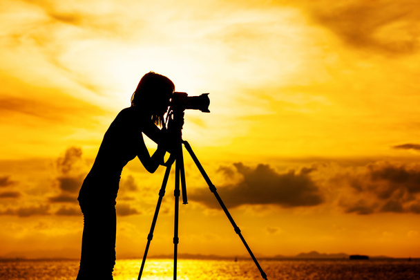 σιλουέτα θηλυκό φωτογράφος στο ηλιοβασίλεμα - Φωτογραφία, εικόνα