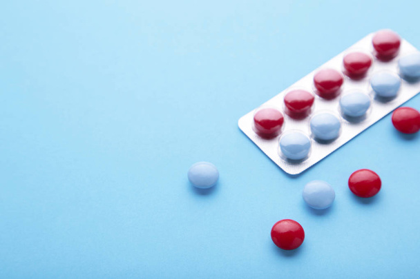 Red and blue tablets on a blue background, top view - Photo, image