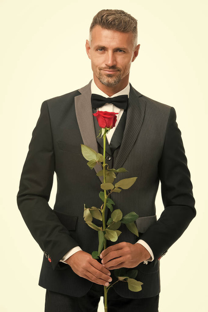 Valentines day and anniversary. Dating services. How to be romantic. Romantic gentleman. Man mature confident macho with romantic gift. Handsome guy rose flower romantic date. Perfectionist concept - Фото, зображення