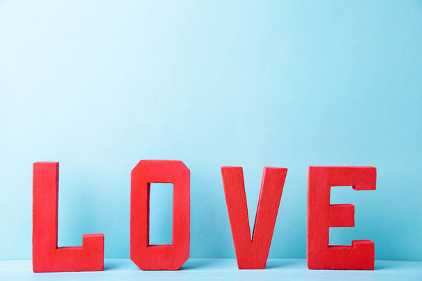 Red letters love on blue background. LOVE word. - Fotoğraf, Görsel