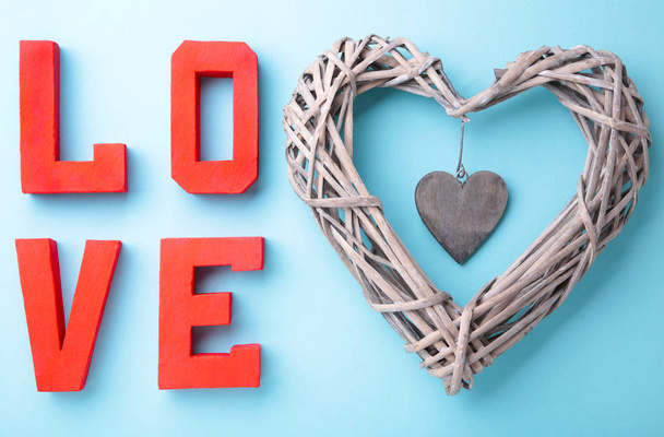 Red letters love with wooden heart on blue background. LOVE word. - Foto, Imagen