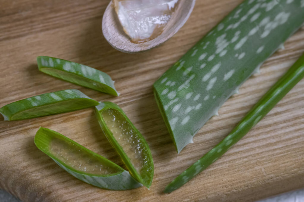 Aloe Vera leaves on a wooden stand. Sliced top view - Foto, Imagen