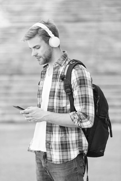 trendy man typing message. College student earphones smartphone. Online education. Audio book concept. Educational technology. student e learning. school life. Listen music. Modern and digital youth - Фото, изображение