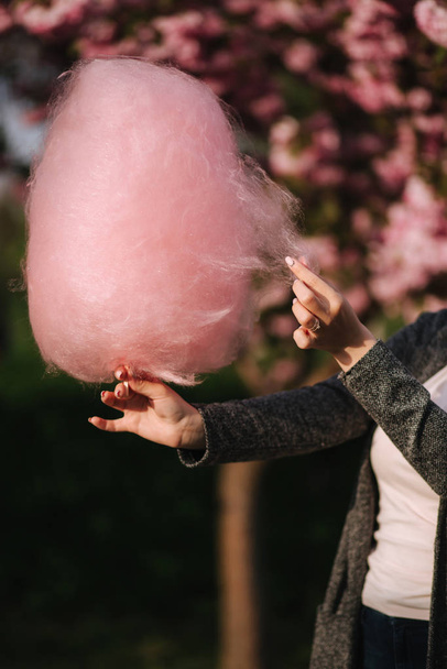 ピンクの綿菓子を持つ女性の手 - 写真・画像