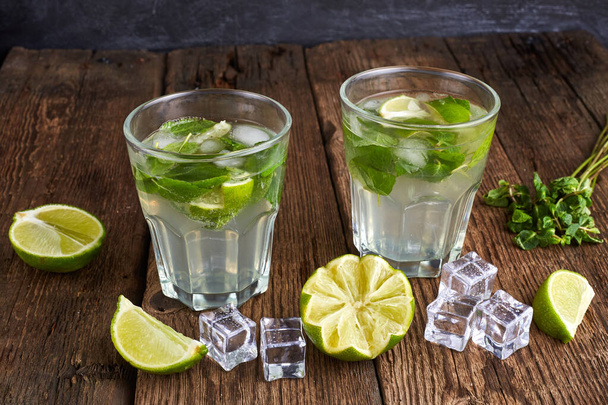 Fresh mojito in glasses with ice cubes on wooden table. - Foto, Imagem