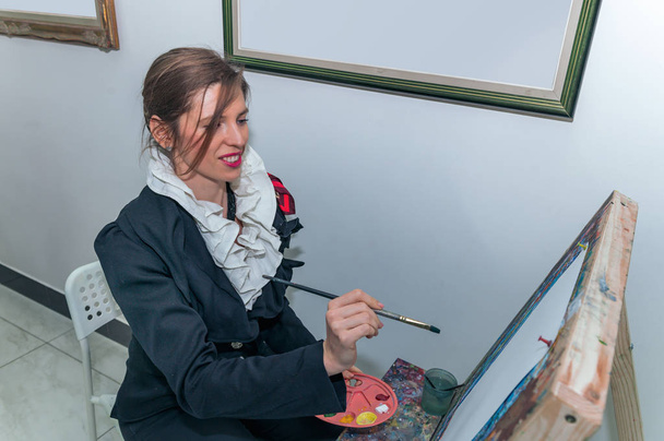 Linda hermosa artista chica pintando un cuadro en un lienzo en un
  - Foto, Imagen