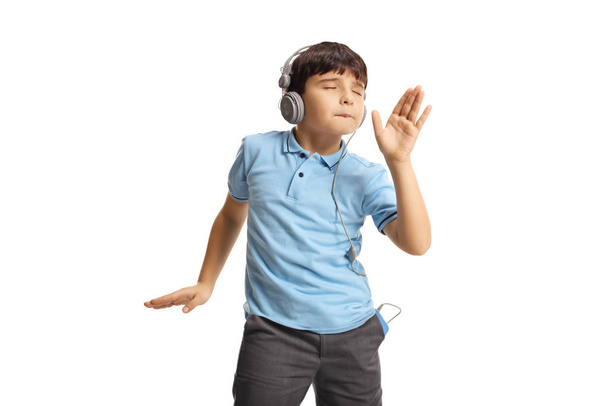 Cheerful child listening to music on headphones and dancing - Fotó, kép