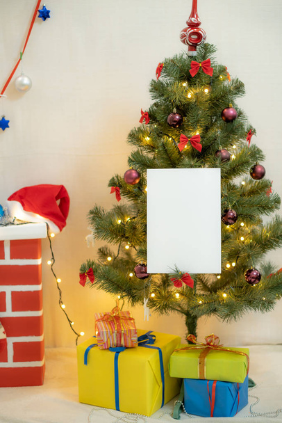 White blank sheet of paper against the background of the Christmas tree and the fireplace - Valokuva, kuva