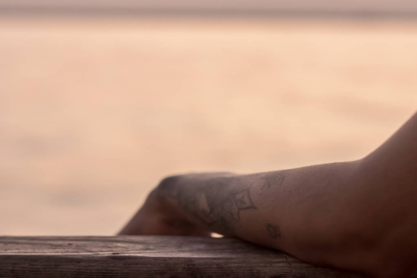 a good looking partial closeup shoot to tattooed girl arm - blur - Foto, immagini