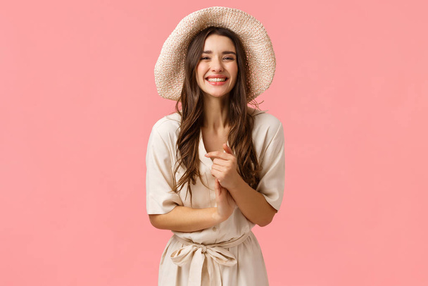 Elegant and feminine beautiful young woman clasp hands and smiling as enjoying nice casual conversation with group friends, shopping, smiling and laughing enthusiastic, pink background - Photo, Image
