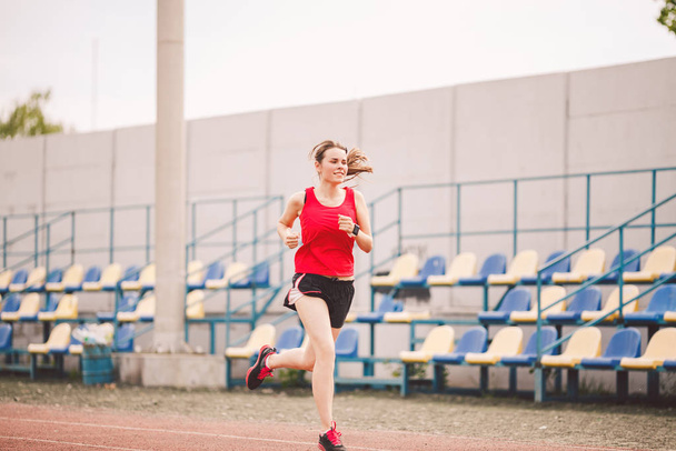 Nainen juoksija lenkkeily stadionilla radalla, nainen urheilija käynnissä ja treenata ulkona, urheilu ja kunto käsite. Nuori nainen urheiluvaatteet koulutus stadionilla. Urheilu elämäntapa aihe
 - Valokuva, kuva