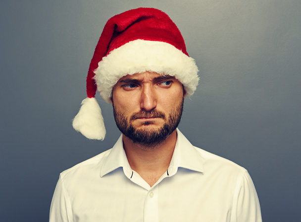 sad man in santa hat over dark - Photo, Image
