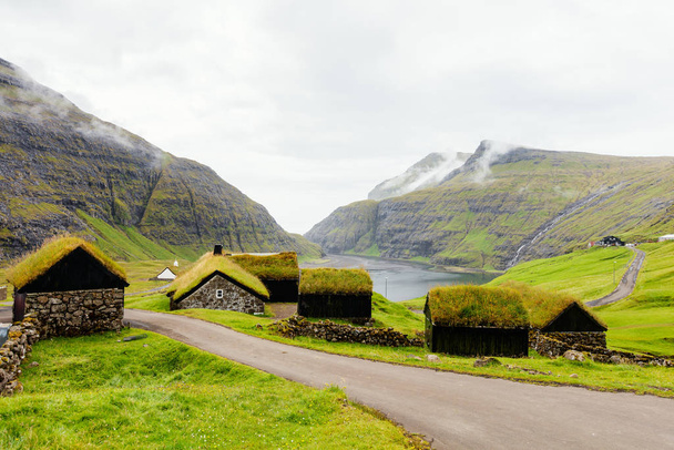 Breathtaking Faroe islands scenery with traditional grass roof houses in village of Saksun - Photo, image